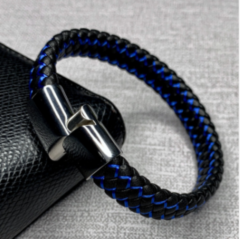 Black and blue braided bracelet with a silver clasp on a textured gray background