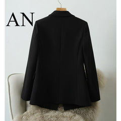 A black long-sleeve blazer jacket displayed on a hanger against a light gray wall, with a large 'AN' logo in the top-left corner.