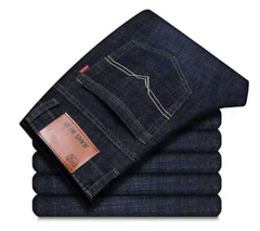 A stack of folded dark indigo denim jeans, with the top pair showing the back pocket, contrast stitching, a leather patch, and a red Levi's tab on a white background.