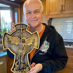 Man holding a decorative plaque with an eagle emblem in a kitchen.