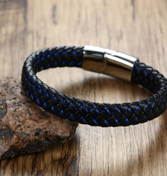 Black braided leather bracelet with blue accents on a wooden surface