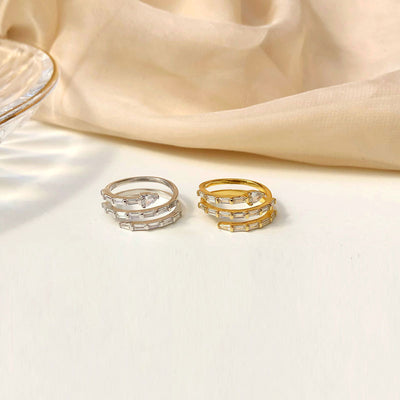 Three gold rings stacked on a beige fabric background