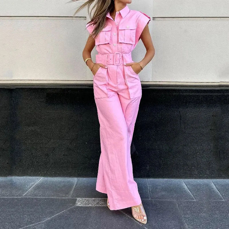 Person wearing a pink jumpsuit standing against a neutral background