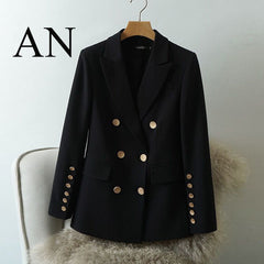 Black blazer with gold buttons on a hanger against a light background