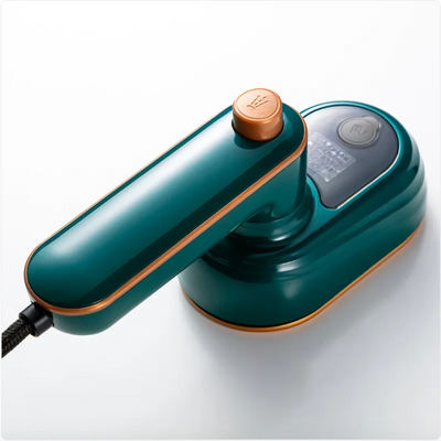 Mini portable electric steam iron with a green and bronze finish on a white background