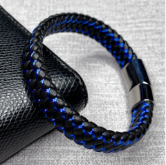 Black and blue braided bracelet on a textured surface