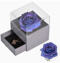 Purple rose in a clear box with a necklace inside, on a white background