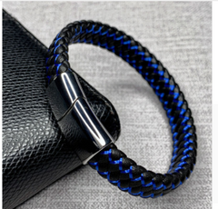 Blue braided bracelet with a metallic clasp on a textured surface