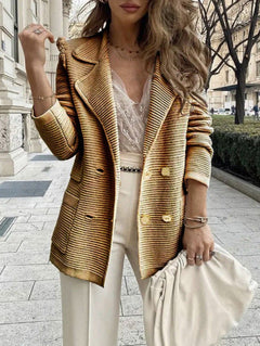 Woman wearing a mustard yellow blazer and white outfit on a city street.