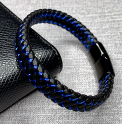 Black and blue braided bracelet on a textured surface