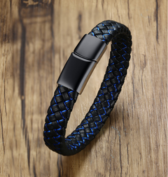 A braided black leather bracelet with a metallic black magnetic clasp, displayed on a rustic wooden surface.