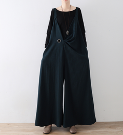 Person wearing a black overalls outfit against a white background