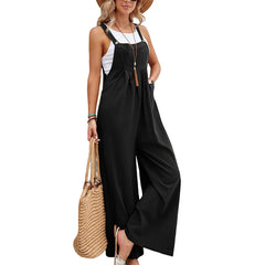 Woman wearing a black jumpsuit holding a straw bag on a white background